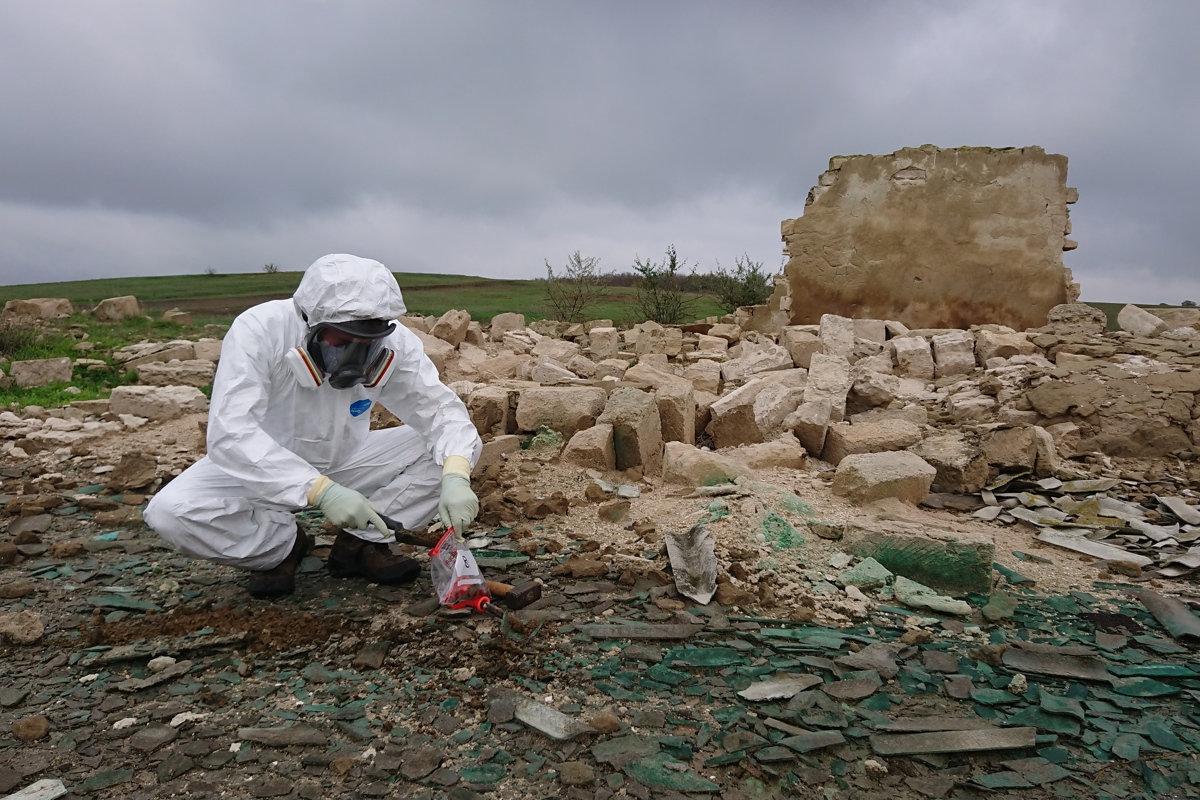 Man collecting samples of rubble